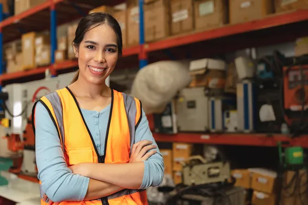 A worker wearing a safety vest shows confidence in her work environment, reflecting the professional presence of a Customs broker Laredo TX in logistics operations.