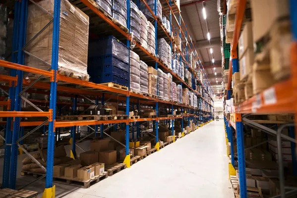 A modern distribution center with shelves filled with boxes and a clear pathway for efficient product movement.